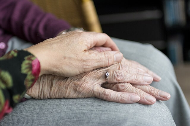 Hands of two old people showing solidarity